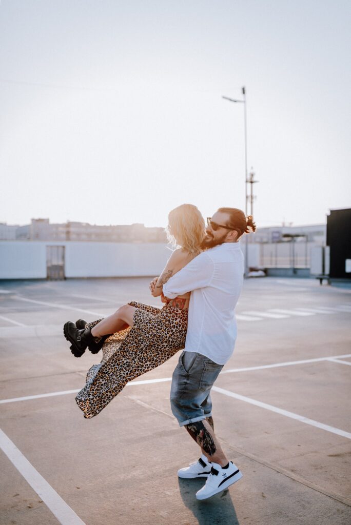 para tańcząca na parkingu na tle zachodzącego słońca