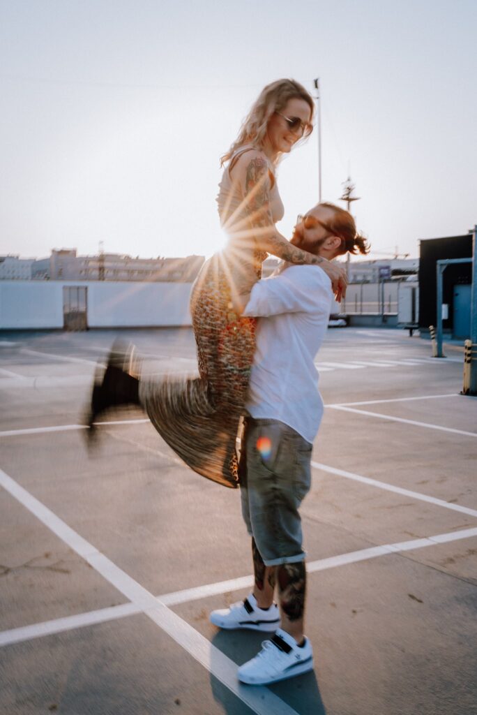 para tańcząca na parkingu na tle zachodzącego słońca