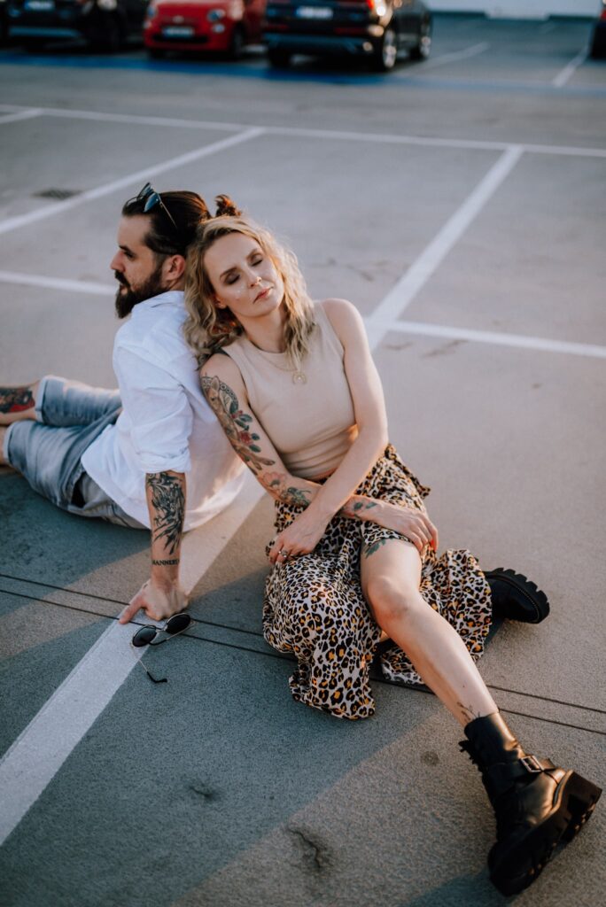 para siedząca na ziemi i przytulająca się na parkingu